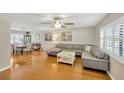 Cozy living room featuring hardwood floors, large windows, and a comfortable gray sectional sofa at 701 Millifold Pl, Brandon, FL 33510