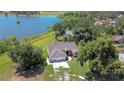 An aerial view of a charming home with a large three-car garage, lush landscaping, and beautiful views of the nearby lake at 709 Sportsman Park Dr, Seffner, FL 33584