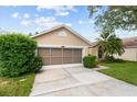 Attractive house with well-kept lawn, green shrubbery, and a two-car garage with screened doors at 7235 Sharpsburg Blvd, New Port Richey, FL 34653