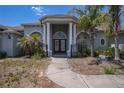 Beautiful front entrance with stately columns, arched windows and a black iron gate at 7285 Nightwalker Rd, Weeki Wachee, FL 34613