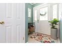 Foyer with a white front door, floral rug, console table, and tile flooring at 7903 Heather Ct, Tampa, FL 33634