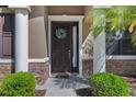 Close-up of the elegant front door with sidelight, decorative wreath, and stone accents at 7911 Hampton Lake Dr, Tampa, FL 33647