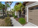 Charming home exterior with palm trees, manicured bushes, and a stone-accented facade at 7911 Hampton Lake Dr, Tampa, FL 33647
