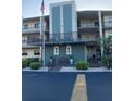 Charming condo building featuring an American flag, well-maintained landscaping and walkway, and covered resident parking at 7951 58Th N Ave # 308, St Petersburg, FL 33709
