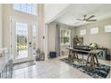Bright foyer features tile floors, a glass paneled door and an office space with a ceiling fan at 11416 Alachua Creek Ln, Riverview, FL 33579