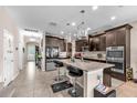 Spacious kitchen featuring an island with bar stools, stainless steel appliances, and ample cabinet space at 11525 Scarlet Ibis Pl, Riverview, FL 33569