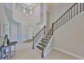 Grand foyer with high ceilings, staircase, and elegant chandelier, creating a welcoming entrance at 11909 Climbing Fern Ave, Riverview, FL 33579