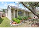 Angle showing stone facade and green trim, surrounded by well-maintained landscaping and a mature tree at 1227 Tuxford Dr, Brandon, FL 33511