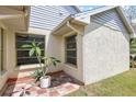 Close-up showcasing textured stucco, tile patio, and green trim accents on a house at 1227 Tuxford Dr, Brandon, FL 33511