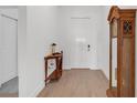 Bright foyer with wood-look tile floors, white walls, and a decorative table and grandfather clock at 12572 Bergstrom Bay Dr, Riverview, FL 33579