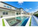 Modern pool and hot tub combination featuring a gray tile patio and well manicured lawn at 13071 Willow Grove Dr, Riverview, FL 33579