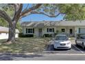 Charming home featuring green shutters, a well-manicured lawn, and a driveway with parking spaces at 1430 Normandy Park Oaks Dr # 9, Clearwater, FL 33756