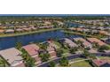 An aerial view showcases a serene lake community with well-maintained homes and lush greenery at 16139 Coquina Bay Ln, Wimauma, FL 33598