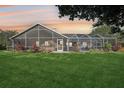 A well-maintained lawn leads to a screened-in patio, offering a perfect outdoor living space at 16910 Equestrian Trl, Odessa, FL 33556