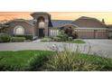 Inviting two-story tan home featuring an arched entryway, a three-car garage, and beautifully landscaped grounds at 16910 Equestrian Trl, Odessa, FL 33556