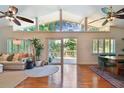 Spacious living room featuring hardwood floors, a vaulted ceiling, and a sliding glass door to the deck at 1735 Maryland Ne Ave, St Petersburg, FL 33703
