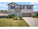 Charming two-story home featuring a well-maintained lawn and a two-car garage at 1823 Moon Cactus Ct, Ruskin, FL 33570