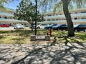 Exterior view of a condo complex with lush greenery, a community sign, and visible parking at 2287 Philippine Dr # 29, Clearwater, FL 33763