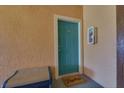 Condo entrance features a teal door, 