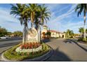 Beautiful community sign welcomes residents with mature landscaping and Mediterranean-style architecture at 2717 Via Cipriani # 631B, Clearwater, FL 33764