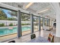 Bright living room with floor-to-ceiling windows offering views of the backyard pool at 307 Orangewood Ln, Largo, FL 33770