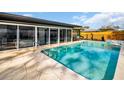 A refreshing pool features a stone surround and is easily accessed from sliding glass doors at 307 Orangewood Ln, Largo, FL 33770