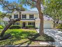 Charming two-story home with mature trees, manicured lawn, welcoming front porch and attached two car garage at 3212 W Villa Rosa St, Tampa, FL 33611