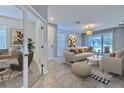 Bright, modern living room with neutral tones and large sliding doors to the outdoor space, complemented by an adjacent office at 32829 Woodthrush Way, Wesley Chapel, FL 33545