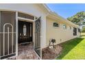 Elegant front entrance with a secure screen door and beautifully landscaped surroundings at 5429 Legend Hills Ln, Spring Hill, FL 34609