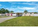 Inviting one-story home featuring a carport and well-maintained lawn at 6010 Blossom Ave, Tampa, FL 33614
