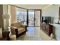 Comfortable living room features neutral color palette and sliding glass doors leading to balcony at 690 Island Way # 1011, Clearwater Beach, FL 33767