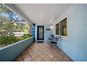 Inviting front porch featuring a stylish door, tiled flooring, and a cozy seating area at 920 16Th Sw Ave, Largo, FL 33770