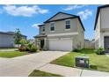 Beautiful two-story home showcasing a well-kept lawn, lush landscaping, and a spacious concrete driveway at 9907 Spanish Lime Ct, Riverview, FL 33578
