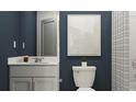 Stylish bathroom with white fixtures, blue walls, and minimalist decor at 10282 Purple Leaf Ct, Riverview, FL 33578