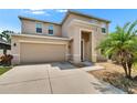 Stylish home showcasing a two-car garage, ample driveway space, accented by a palm tree and manicured landscaping at 12150 Ledbury Commons Dr, Gibsonton, FL 33534