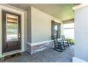 Inviting front porch with stone accents and two rocking chairs at 12462 Rangeland Blvd, Odessa, FL 33556