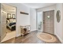 Bright foyer with wood floors, a side table, and hallway leading to the bedroom at 13749 80Th Ave, Seminole, FL 33776