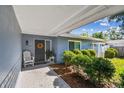 Inviting front porch with rocking chair, decorative wreath, and meticulous landscaping creates a warm welcome at 13749 80Th Ave, Seminole, FL 33776