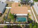 Aerial view of a home with a screened in pool, fenced yard and storage shed at 1615 Loghill Pl, Brandon, FL 33510