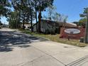 Welcoming entrance to The Villas of Sunset Grove with landscaped signage and well-maintained surroundings at 2055 Sunset Point Rd # 3804, Clearwater, FL 33765
