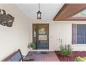 Inviting front porch with a decorative door, brick accents, and a cozy bench for relaxation at 2072 Maguire Ave, Spring Hill, FL 34608