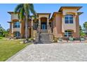 A captivating home featuring a welcoming grand entrance with stone accents and mature palm trees at 2605 59Th S St, Gulfport, FL 33707