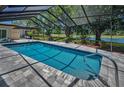 Relaxing screened-in pool area with views of a golf course and pond at 2950 Meadow Hill Dr, Clearwater, FL 33761