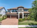 Beautiful two-story home featuring a barrel tile roof, manicured landscaping, and a three-car garage at 3100 Barbour Trl, Odessa, FL 33556