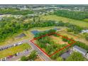 Aerial view showcasing the property's layout, surrounding greenery, and nearby water feature at 3611 W Reynolds St # 1/2, Plant City, FL 33563
