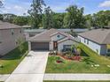 Single-story home with mature trees, manicured lawn and inviting curb appeal at 36568 Garden Wall Way, Zephyrhills, FL 33541