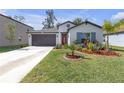 Charming single-story home with a well-manicured lawn and colorful landscaping at 36568 Garden Wall Way, Zephyrhills, FL 33541
