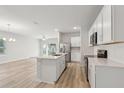 Open-concept kitchen featuring a central island, stainless steel appliances, and hardwood floors at 4086 Polynesia Rd, North Port, FL 34288