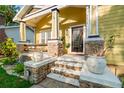 Inviting front porch featuring stone accents, white columns, and a cozy seating area at 5804 N 9Th St, Tampa, FL 33604