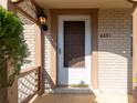 Charming front porch featuring decorative lattice work, a stylish light fixture, and the house number above the door at 6251 Danbury St, Spring Hill, FL 34606